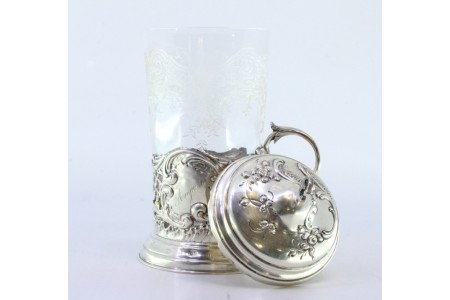 Porta copos em prata recortada com cartela para monograma envolvido por motivos florais e volutas, tampa com pomo e vidro com gravados a ácido.